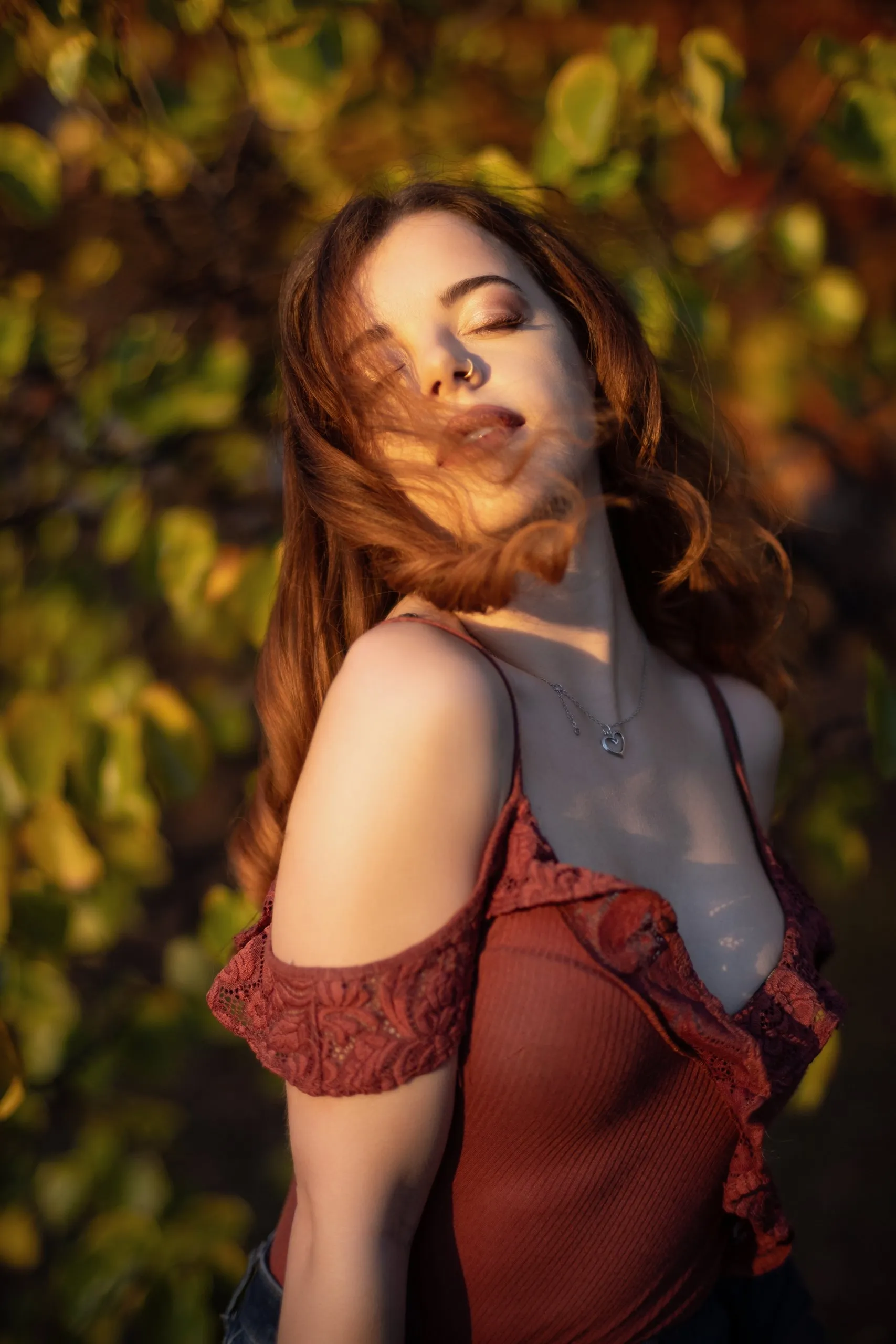 Quiet golden-hour portrait with closed eyes and wind moving through her hair