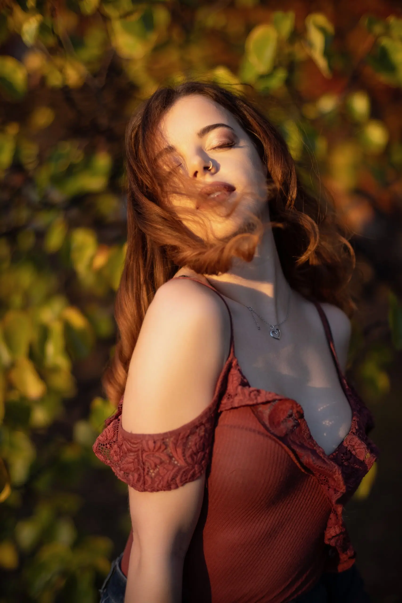 Quiet golden-hour portrait with closed eyes and wind moving through her hair